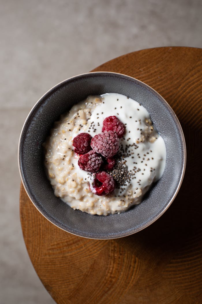 Delicious bowl of oatmeal with raspberries, yogurt, and chia seeds from above.