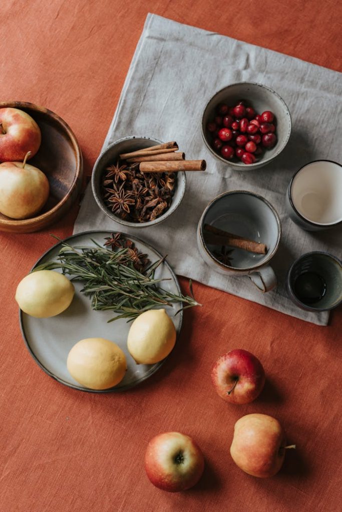 pexels-photo-5742698 Flatlay of apples, lemons, star anise, and cinnamon creating a rustic still life setup.